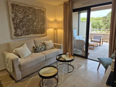 a living room with a couch and a table at Appartement Neuf Grande Terrasse AGOSTA PLAGE in Albitreccia