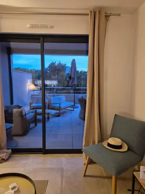 a living room with sliding glass doors and a patio at Appartement Neuf Grande Terrasse AGOSTA PLAGE in Albitreccia