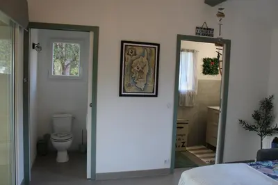 a bedroom with a door leading to a bathroom with a toilet at Studio Villa Boca in Prunelli-di-Fiumorbo