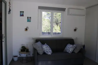 a living room with a couch and a window at Studio Villa Boca in Prunelli-di-Fiumorbo
