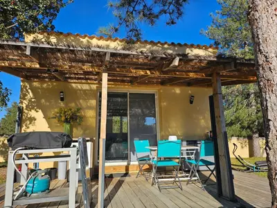 a deck with chairs and a pergola at Studio Villa Boca in Prunelli-di-Fiumorbo
