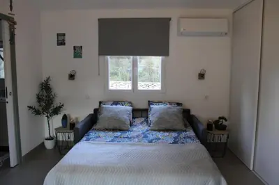 a bedroom with a bed with a white bedspread and a window at Studio Villa Boca in Prunelli-di-Fiumorbo