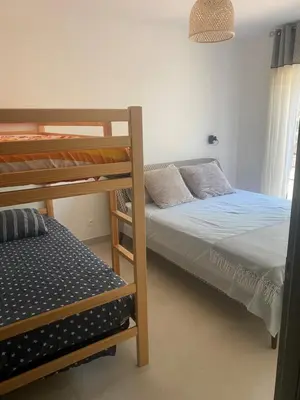 a bedroom with a bed and a large window at Maison Rez-de-jardin 80 m de la plage in Serra-di-Ferro