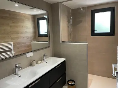 a bathroom with two sinks and a large mirror at Maison Rez-de-jardin 80 m de la plage in Serra-di-Ferro