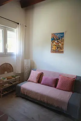 a couch in a living room with a painting on the wall at Appartement calme & cosy vue montagne in Corte