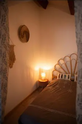 a bedroom with a bed and a table with a lamp at Appartement calme & cosy vue montagne in Corte