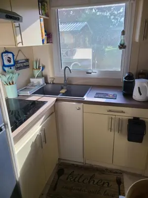 a kitchen with a sink and a window at Chalet en bois climatisé À 300 m de la plage Marina di Sorbo 6 personnes in Sorbo-Ocagnano