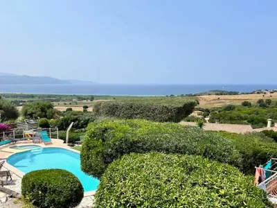 a view of a swimming pool and some bushes at villa vue mer avec piscine et jardin arboré in Coggia
