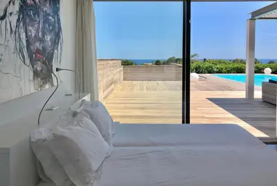 a bedroom with a bed and a view of a pool at Villa Isulana, piscine chauffée, vue mer, proche Pinarello in Zonza