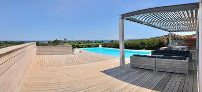 a wooden deck with a pool in a house at Villa Isulana, piscine chauffée, vue mer, proche Pinarello in Zonza