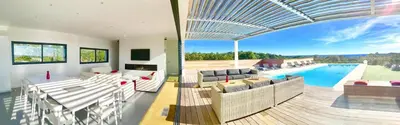 a living room with a view of a swimming pool at Villa Isulana, piscine chauffée, vue mer, proche Pinarello in Zonza