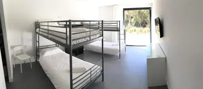 three bunk beds in a room with a hallway at Villa Isulana, piscine chauffée, vue mer, proche Pinarello in Zonza