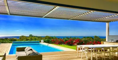 a patio with a pool and a table and chairs at Villa Isulana, piscine chauffée, vue mer, proche Pinarello in Zonza