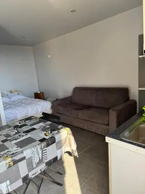 a kitchen with a couch and a table in a room at Studio in Sartène