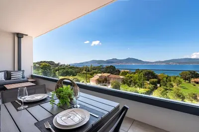 a dining room with a table and a large window at A Sereina - appt climatisé proche de la plage in Grosseto-Prugna