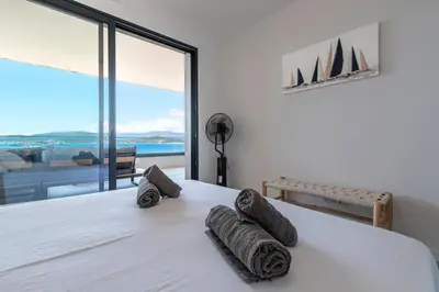 a bedroom with a bed with rolled towels on it at A Sereina - appt climatisé proche de la plage in Grosseto-Prugna