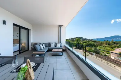 a living room with a couch and a balcony at A Sereina - appt climatisé proche de la plage in Grosseto-Prugna