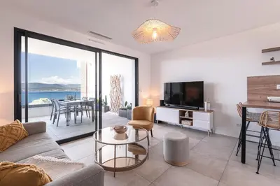 a living room with a couch and a tv at A Sereina - appt climatisé proche de la plage in Grosseto-Prugna