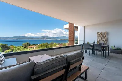 a living room with a couch and a view of the ocean at A Sereina - appt climatisé proche de la plage in Grosseto-Prugna