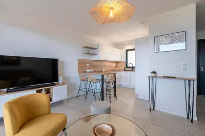 a living room with a television and a table at A Sereina - appt climatisé proche de la plage in Grosseto-Prugna