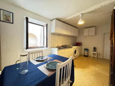 a kitchen with a table with a blue table cloth at L'Alcôve - Wifi, TV, Central in Bonifacio