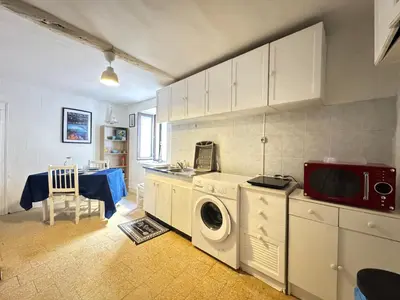 a kitchen with a washing machine and a microwave at L'Alcôve - Wifi, TV, Central in Bonifacio