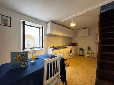 a kitchen with a blue table in the middle of it at L'Alcôve - Wifi, TV, Central in Bonifacio