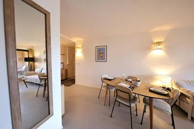 a dining room with a table and a mirror at U Mare - T2 cabine avec vue mer, plage & piscine in Pianottoli-Caldarello