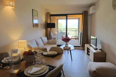 a living room with a couch and a table at U Mare - T2 cabine avec vue mer, plage & piscine in Pianottoli-Caldarello