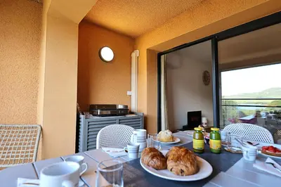 a table with two plates of food on top of it at U Mare - T2 cabine avec vue mer, plage & piscine in Pianottoli-Caldarello