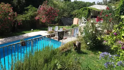a swimming pool in a garden with flowers at L'Olettese in Oletta