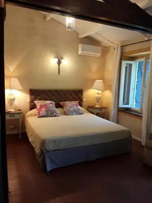 a bedroom with a bed with two lamps and a couch at L'Olettese in Oletta