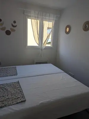 a white bedroom with a large bed and a window at Joli cocon à Ajaccio avec terrasse vue mer in Ajaccio