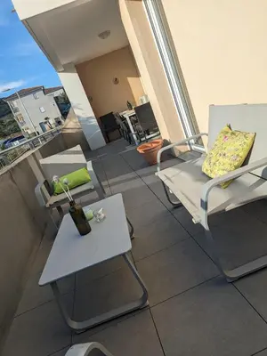 a balcony with a table and chairs on a building at Joli cocon à Ajaccio avec terrasse vue mer in Ajaccio