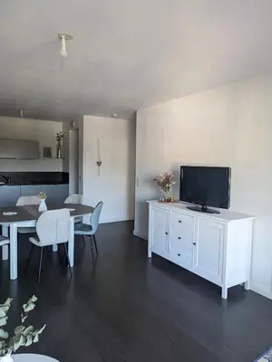 a living room with a table and a television on a cabinet at Joli cocon à Ajaccio avec terrasse vue mer in Ajaccio