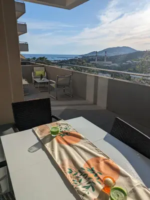 a table and chairs on a balcony with a view at Joli cocon à Ajaccio avec terrasse vue mer in Ajaccio