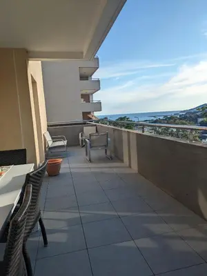 a balcony with two chairs and a view of the ocean at Joli cocon à Ajaccio avec terrasse vue mer in Ajaccio