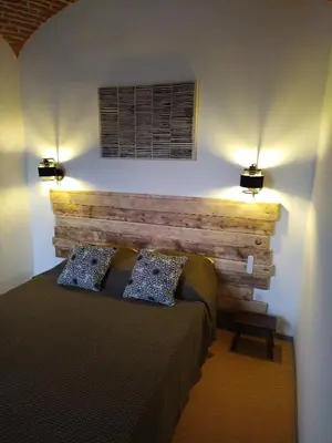 a bedroom with a bed with two pillows and two lights at U Casone in Aléria