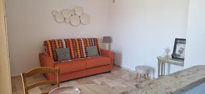 a living room with an orange couch and a table at Bella vista in Costa