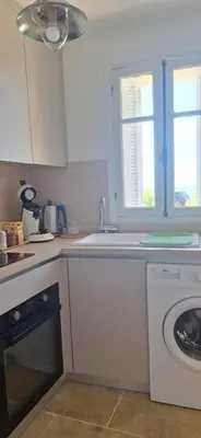 a kitchen with a sink and a washing machine at Bella vista in Costa