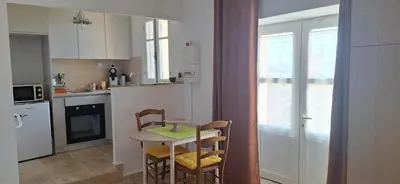 a kitchen with a small table and chairs and a kitchen with white cabinets at Bella vista in Costa