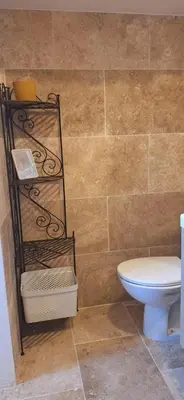 a bathroom with a toilet and a shelf next to a wall at Bella vista in Costa