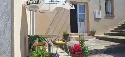 a table with an umbrella in front of a building at Bella vista in Costa