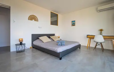 a bedroom with a bed and a desk at Villa Spacieuse Proche Plages in Vardiola