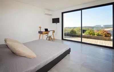 a bedroom with a bed and a large window at Villa Spacieuse Proche Plages in Vardiola