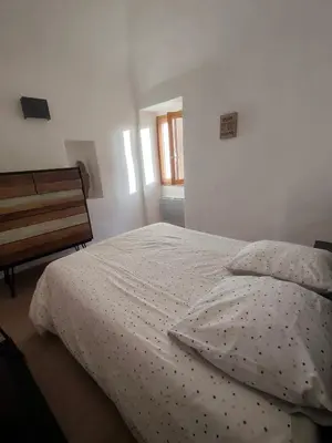 a bedroom with a bed and a window at Les voûtes de Pascaline, vue mer et montagne, Lama in Lama