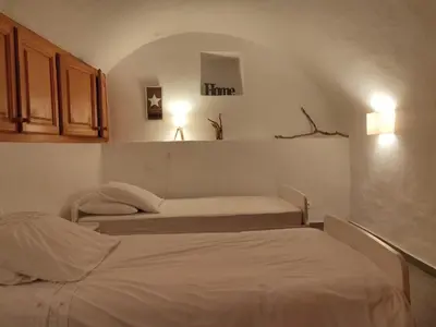 two beds in a small room with a room with at Les voûtes de Pascaline, vue mer et montagne, Lama in Lama
