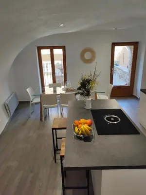 a kitchen with a table with a bowl of fruit on it at Les voûtes de Pascaline, vue mer et montagne, Lama in Lama