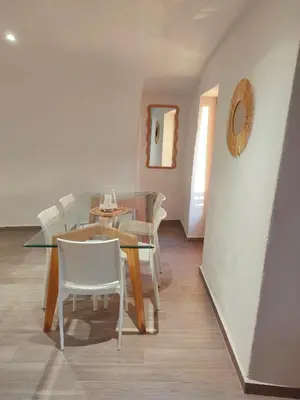 a dining room with a glass table and white chairs at Les voûtes de Pascaline, vue mer et montagne, Lama in Lama