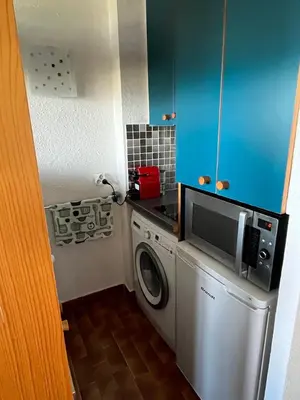 a small kitchen with a washing machine and a microwave at Charmant 2 pièces avec vue sur mer exceptionnelle à Porticcio, Corse du Sud in Grosseto-Prugna